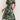 Tropical Leaf V-Neck Mini Dress in green, size XL, featuring a bohemian summer resort style. The dress showcases a sheath silhouette with a one-piece garment design, highlighting the shoulders and arms.