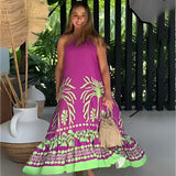 Tropical maxi dress in a purple and green palm design, featuring a kaftan style with sleeves, worn by a smiling person outdoors.