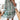 Tropical Print Button-Up Mini Dress in light green with pink accents, modeled by a person wearing the dress. The dress features short sleeves and a mini length, highlighting a vibrant summer style. The model's arms and legs are visible, emphasizing the dress's fit and style.