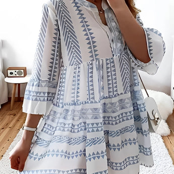 Tropical print button-up mini dress in blue, featuring a vibrant summer style with patterns and short sleeves, modeled to showcase its fashionable fit and design.