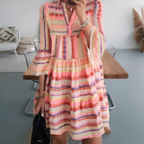 Tropical print button-up mini dress featuring a vibrant green and pink pattern, styled for summer. The dress is modeled in an orange variant in size 3XL, showcasing a one-piece garment with a classic button-up design. The model's hand is positioned on the hip, highlighting the shoulder and neckline details.