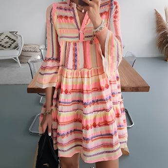 Tropical print button-up mini dress featuring a vibrant green and pink pattern, styled for summer. The dress is modeled in an orange variant in size 3XL, showcasing a one-piece garment with a classic button-up design. The model's hand is positioned on the hip, highlighting the shoulder and neckline details.