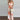 A model wearing a tropical print halter maxi dress suitable for beach weddings and resort wear, accessorized with sunglasses and a bag, highlighting the dress's flowing design that fits comfortably around the waist and falls elegantly to the thighs and knees.