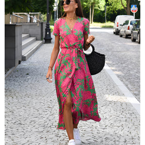 Tropical print V-neck wrap dress in pink and green, featuring short sleeves and a midi length, perfect for summer wear.