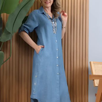 Turquoise linen asymmetrical hem long sleeve summer dress worn by a person standing, with focus on the dress's unique design and vibrant color.