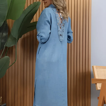Turquoise linen asymmetrical hem long sleeve summer dress displayed on a standing mannequin, showcasing the fitted waist and flowing knee-length design.