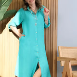Turquoise linen summer dress with asymmetrical hem and long sleeves, displayed on a mannequin.