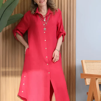 
A person wearing a turquoise linen asymmetrical hem long sleeve summer dress.
