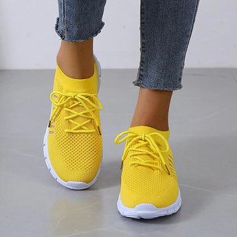 Turquoise women's breathable mesh sneakers, lightweight running shoes in yellow, size 44, worn with denim pants.