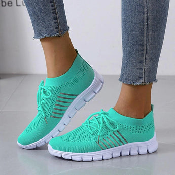 Turquoise Women's Breathable Mesh Sneakers - Lightweight Running Shoes with white soles and black accents, displayed on a human leg.