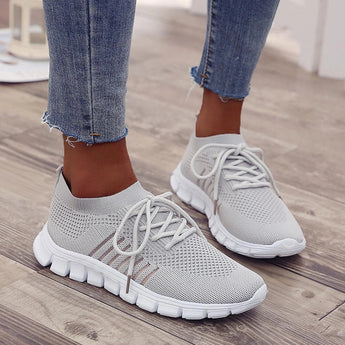 Turquoise women's breathable mesh sneakers in gray, size 44, shown on a person standing, lightweight running shoes designed for comfort and performance.