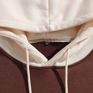 A two-tone beige hooded sweatshirt in size small, featuring a casual design with a hood and long sleeves.