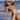 Woman wearing a two-tone blue and black string bikini with adjustable straps, standing on a beach.