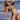 Woman wearing two-tone blue and black string bikini, standing on the beach.