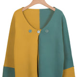 A handmade wool sweater featuring a two-tone design in green and electric blue, displayed on a clothes hanger. The sweater is unisex and eco-friendly, showcasing a high collar, long sleeves, and a cozy knit texture.