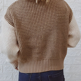 A two-tone chunky knit bomber jacket designed for women, featuring a grey and contrasting color scheme, with a textured outerwear style perfect for winter fashion. The jacket has a prominent shoulder design, a comfortable neckline, long sleeves, and a waist-length fit, modeled in a standing pose showcasing the garment's structure and trendy appeal.