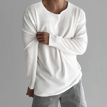 Unisex lightweight long-sleeve white crewneck t-shirt displayed on a person, showcasing the garment's fit on the shoulders and waist with visible sleeves.
