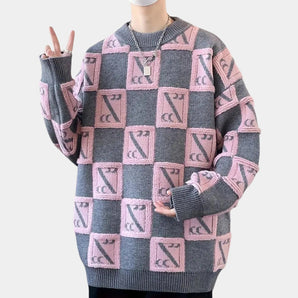 Unisex oversized wool check sweater in pink and gray, featuring a cozy winter design with a focus on the shoulder, arm, and neck areas, highlighting the garment's textile details and comfortable fit.