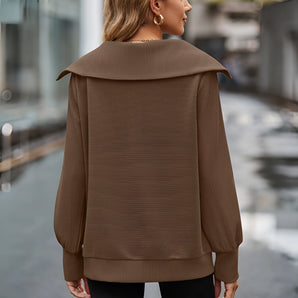 Urban Chic Brown Oversized Hooded Cape Sweater being worn by a person, showcasing its loose fit and long sleeves, with the hood draped over the shoulders, highlighting a fashionable and cozy outerwear style.