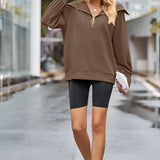 Urban Chic Brown Oversized Hooded Cape Sweater featuring a cozy design with a wide collar and long sleeves, modeled by a person wearing sunglasses. The sweater drapes comfortably around the waist and thighs, blending fashion-forward style with practicality.