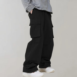 Men's black oversized cargo pants with multiple pockets, worn by a person showcasing their urban style.