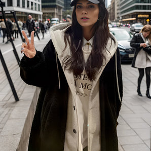 Urban women's faux fur trim coat featuring long sleeves, designed for winter streetwear fashion, modeled by a woman wearing sunglasses, with her hand on her waist.