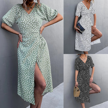Black and white polka dot wrap midi dress with a V-neckline, featuring short sleeves and a cinched waist, perfect for summer fashion.