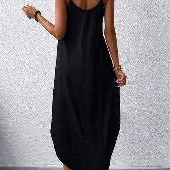 A woman wearing a versatile sleeveless maxi dress with pockets, ideal for summer casual beachwear. The dress highlights her shoulders and legs, with a comfortable waist fit and flowing one-piece garment design.
