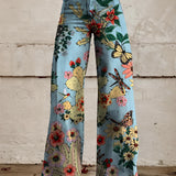 Woman wearing Vibrant Floral Print Bell-Bottom Jeans in Blue Forest color, high-waist, wide-leg denim with a boho style, size 5XL.