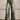 A pair of dark blue, high-waist bell-bottom jeans with a vibrant floral print, shown in size 5XL, worn by a person standing on a road surface.