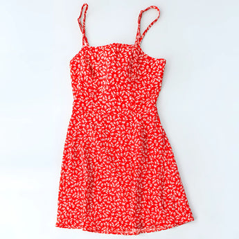 
A red sleeveless summer sundress with a vibrant floral print, designed for daytime wear, displayed on a mannequin or hanger.