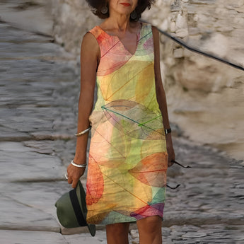 Sleeveless summer dress with a vibrant leaf pattern in yellow, shown in 4XL size, highlighting the shoulders, neck, and waist.
