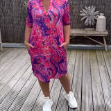 Vibrant Paisley V-neck women's summer dress in purple and pink, featuring short sleeves and a flattering waistline, designed for plus-size.