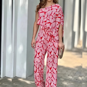 A vibrant pink leaf print asymmetric one-shoulder summer jumpsuit in XL, showcasing a stylish and fashionable design with a focus on the leg, waist, and thigh areas.