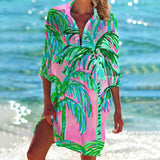 Vibrant pink tie-dye beach cover-up tunic dress with flowing sleeves and a boho style, set against a natural outdoor backdrop with hints of green and azure tones.