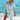 Woman wearing a blue coral tie-dye beach cover-up dress, standing on the beach, smiling and enjoying the summer.