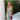 Purple watercolor sheer off-shoulder maxi evening dress with flowing sleeves, cinched waist, and thigh-length design, set against a grassy natural background.