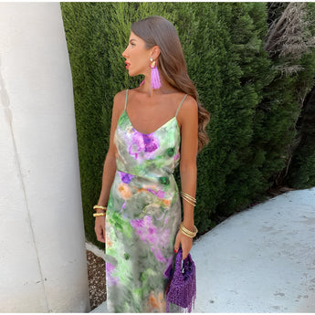 Purple watercolor sheer off-shoulder maxi evening dress with flowing sleeves, cinched waist, and thigh-length design, set against a grassy natural background.