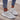 Gray women's lightweight neon running shoes displayed on a model's feet, showcasing the breathable and fashionable design ideal for sportswear. The shoes have a blend of gray and black tones, with the model standing on a neutral background.