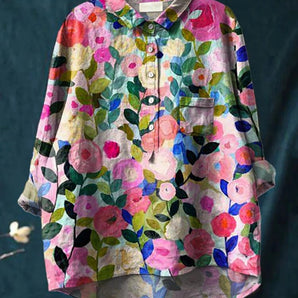 
A vibrant women's oversized floral linen shirt featuring a spring garden print. The shirt is predominantly white with pink and magenta floral patterns, has a collar, and long sleeves. Sized 5XL, this shirt showcases a creative and artistic design suitable for the spring season.