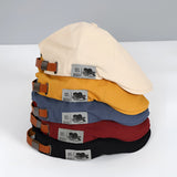 Vintage blue cotton newsboy cap featuring an adjustable buckle strap, displayed against a neutral background.