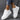 Vintage blue suede high sole sneakers for women, styled with white accents. The sneakers are showcased against a casual backdrop, complementing denim jeans and a hand slightly touching the shoes to highlight their retro fashion appeal.