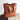 Vintage brown distressed leather tote bag with shoulder straps, handcrafted luxury design, displayed on a wooden surface.