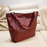 Vintage brown distressed leather tote bag, handcrafted, rectangular shape, luxury fashion accessory with a comfortable and stylish design.