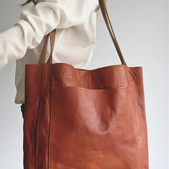 Vintage brown distressed leather tote bag, handcrafted luxury handbag with shoulder straps and spacious interior.