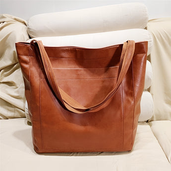 Vintage brown distressed leather tote bag, handcrafted with luxury materials, rectangular shape, and shoulder strap.