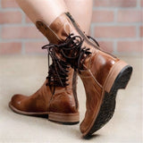 Brown vintage leather lace-up boots with a distressed style and side zipper, shown on a person's legs.