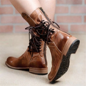 Brown vintage leather lace-up boots with a distressed style and side zipper, shown on a person's legs.