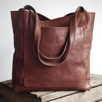 Handmade rustic tan distressed leather tote bag in coffee color, designed for over-the-shoulder use with a rectangular shape.