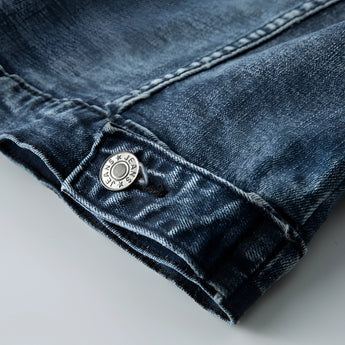 Vintage men's dark wash distressed denim jacket in classic trucker style, featuring long sleeves, visible stitching, and an electric blue tint.